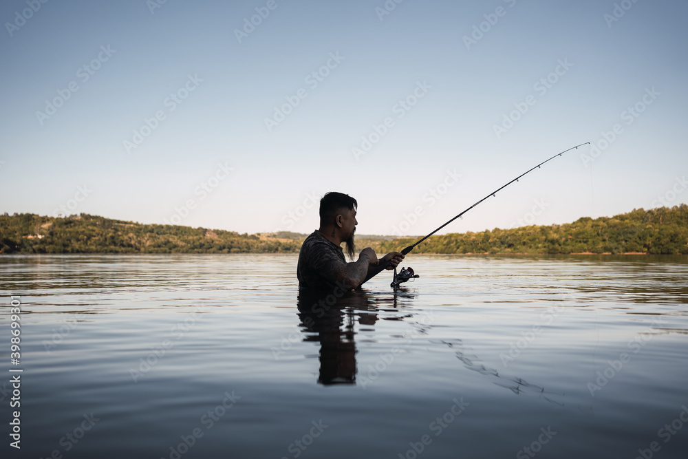 A young fisherman fishing - Asian man fishing in the river at sunset.
