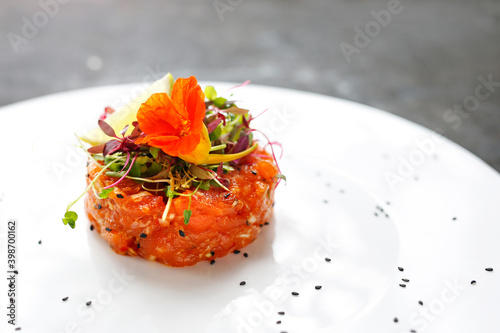 Salmon tartare with edible florals. A light appetizing appetizer