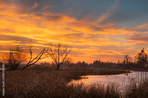 Fototapeta Naklejka Na Ścianę i Meble -  Pomarańczowe niebo o wschodzie słońca nad jeziorem
