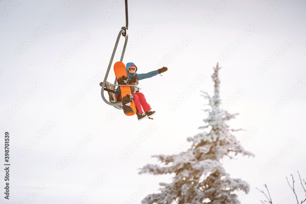 Woman waving hand from ski lift