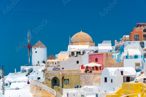 Stunning, amazing and beautiful classic white and caramel color Greek architecture with unbelievable wind mills on Santorini volcano Cyclades Caldera island, Aegean sea in Greece.