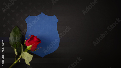 Blue shield with a red rose draped across it. National Law Enforcement Officers Memorial Fund symbol
