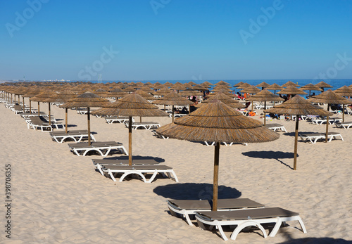 Many Umbrellas on the beach with blue sky in Tavira island,Portugal © Leklife