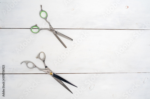 Flat lay with silver hairdressing scissors. Barber scissors on white wooden background and copy space. © Елена Гурова