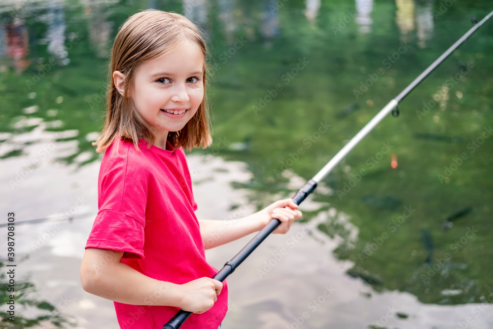 Little girl holding fishing rod on pond background Little girl holding fishing rod on pond background