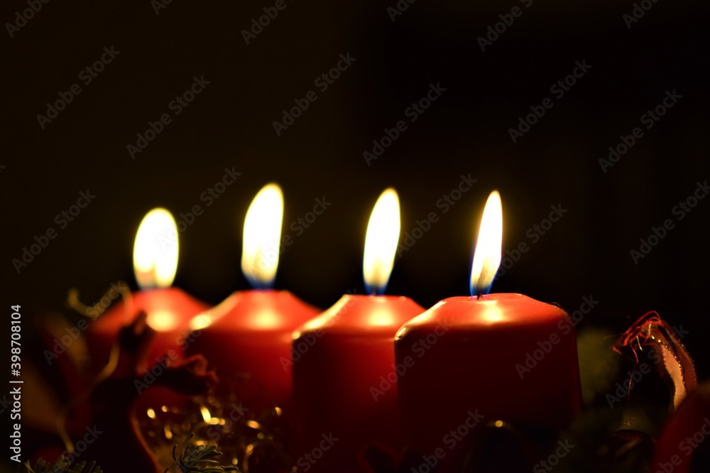 close up of an Advent arrangement with four burning candles close up of an Advent arrangement with four burning candles