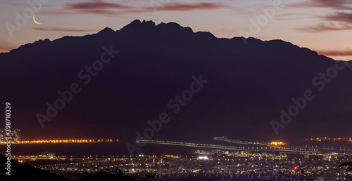 Scenic view on glittering night city beneath mountains of great African rift,...