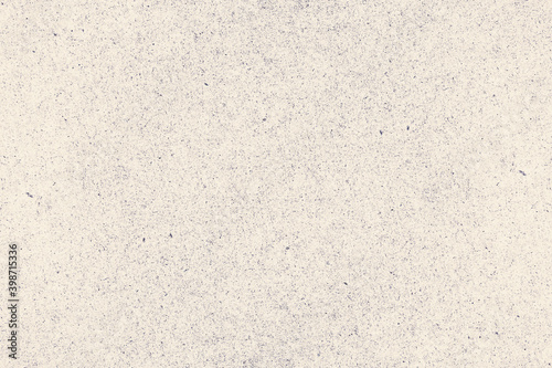 Worn and rough beige background with dots and specks of dust. Grunge texture of antique cardboard