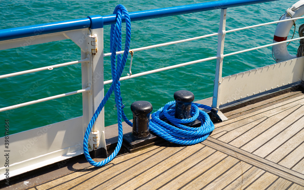Foto de Blue rope of mooring line and two mooring bollards on ship's