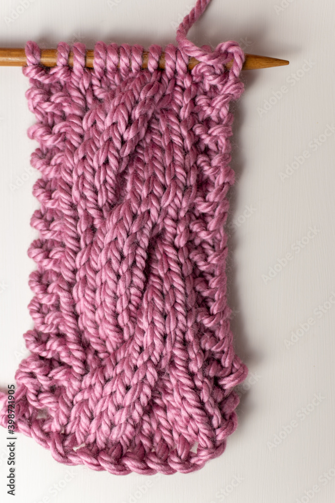Fototapeta premium super chunky cable knitting on needle with pink yarn 
