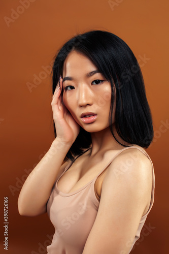 young pretty asian woman cheerful smiling posing on warm brown background  lifestyle people concept