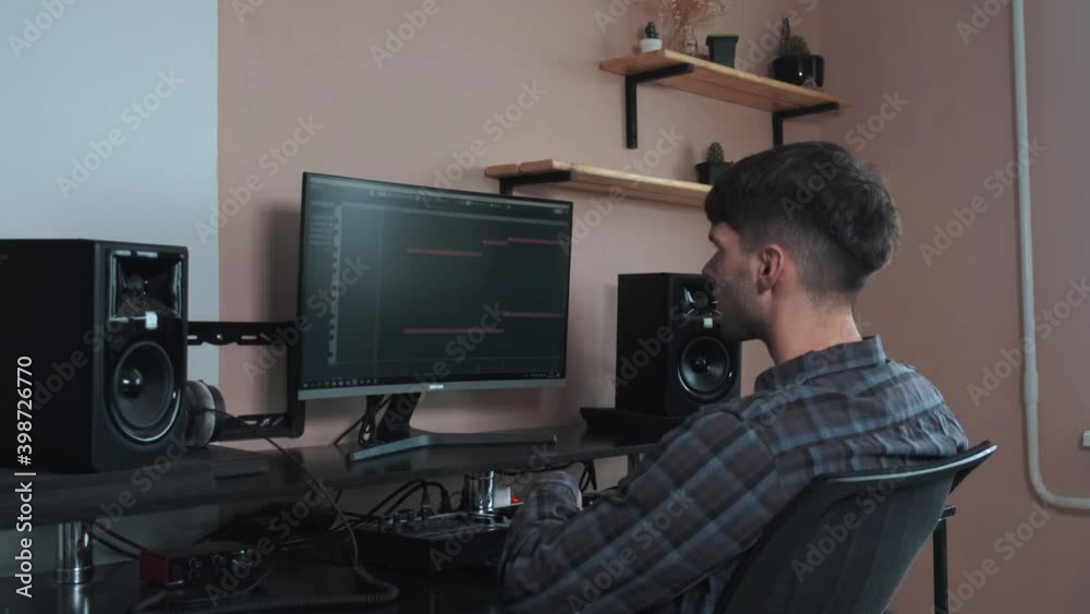 The musician works on a computer and creates a musical composition. The musician works on a computer and creates a musical composition.