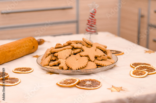 Festive Christmas still life in the kitchen, gingerbread cookie, rolling pin, garland lights, oranges, Christmas tree photo