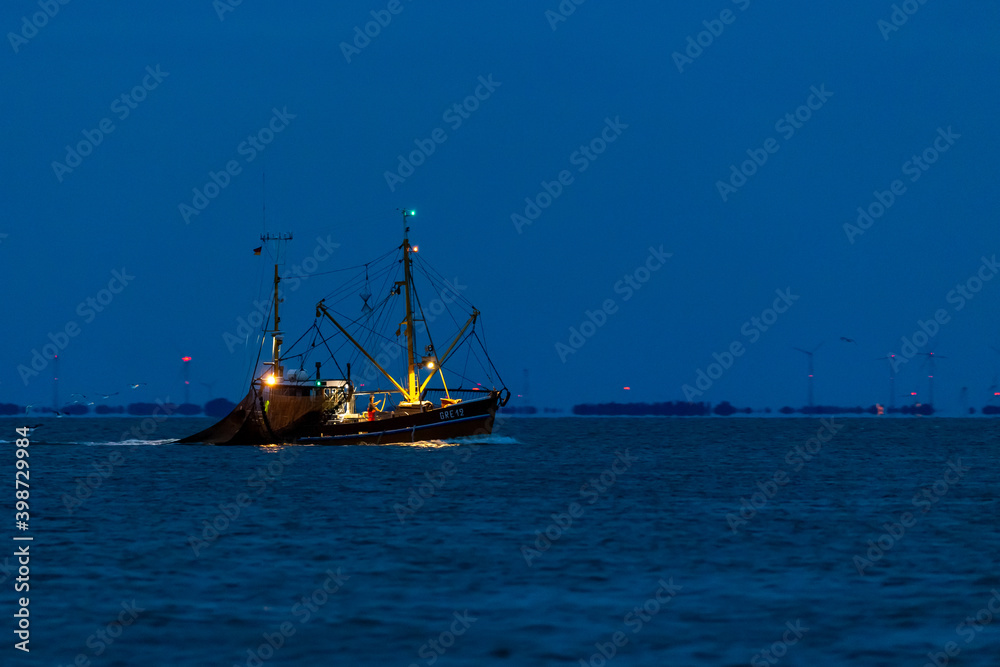 Shrimp boat fishing at night in the wadden sea at the East Frisian island Juist, Germany. Shrimp boat fishing at night in the wadden sea at the East Frisian island Juist, Germany.