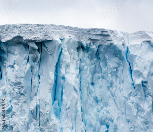 Angular iceburg with deep turquoise crevices floats near Danko Island in Antarctica