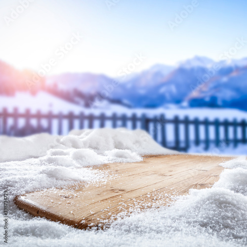 Fresh snow on a wooden table with an alpine view of the mountains © magdal3na