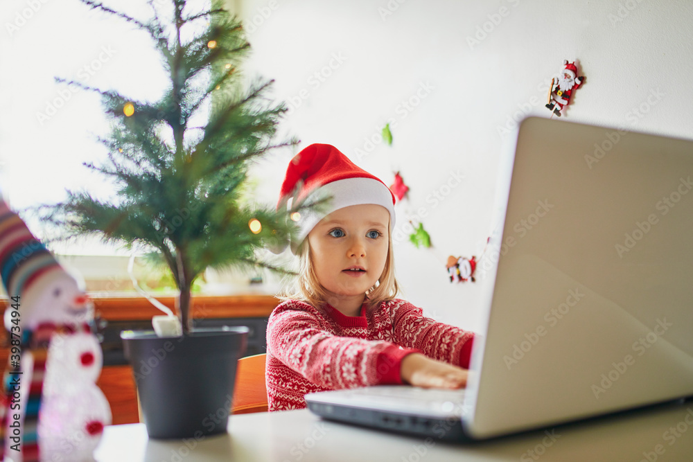 Kid using computer to communicate with friends or elderly relatives on Christmas or New Year Kid using computer to communicate with friends or elderly relatives on Christmas or New Year