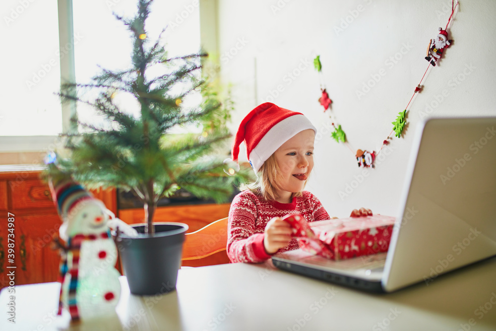 Kid using computer to communicate with friends or elderly relatives on Christmas or New Year Kid using computer to communicate with friends or elderly relatives on Christmas or New Year