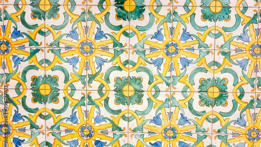 typical colorful Sicilian floor and wall tiles in different patterns and designs. The main colors are yellow, white, blue and green.