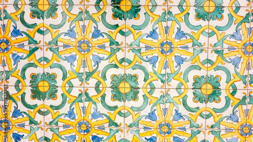 typical colorful Sicilian floor and wall tiles in different patterns and designs. The main colors are yellow  white  blue and green.