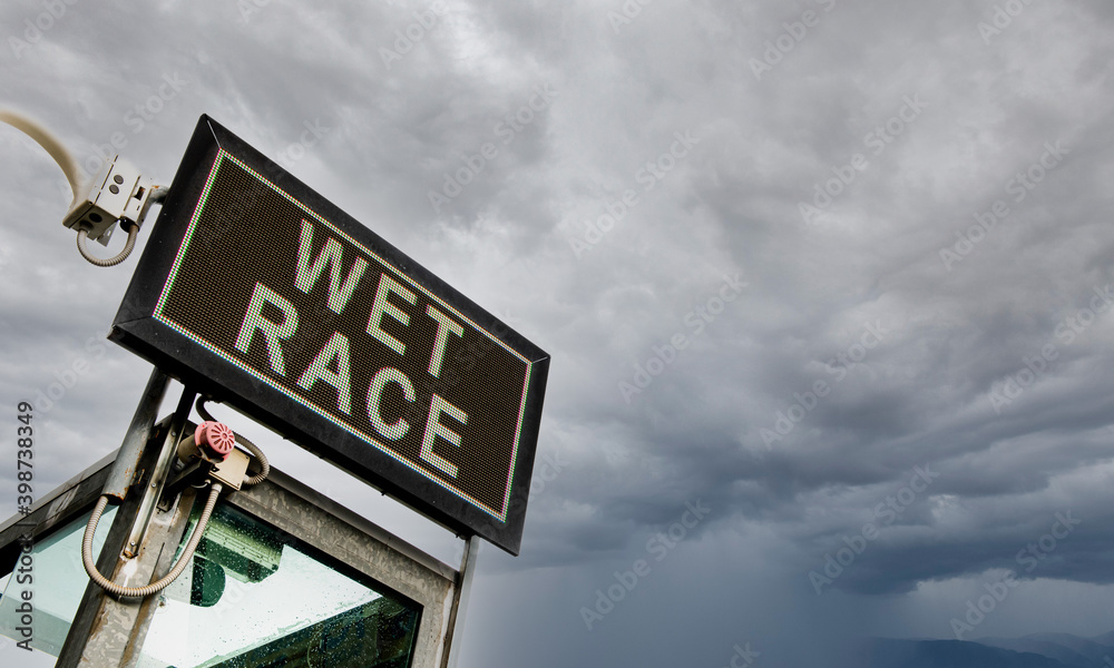 Wet race announcement text motorsport sign low angle view with cloudy sky in background Wet race announcement text motorsport sign low angle view with cloudy sky in background