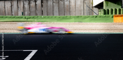 Speed concept blurred motion racing car on asphalt track side view