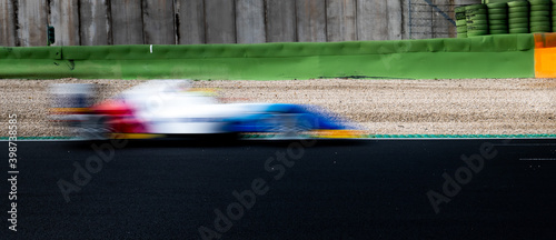 Speed concept blurred motion racing car on asphalt track side view