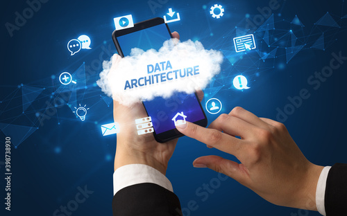 Female hand holding smartphone with DATA ARCHITECTURE inscription, cloud technology concept