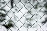 Wire mesh fence texture front view shallow depth of field snowy landscape background