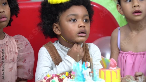 african afro boy in birthday with cake . Group diversity kids celebrating birthday to friend in party at home. multi ethnic  children having fun together