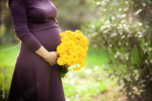 woman with bouquet of flowers.pregnant woman with yellow bouquet