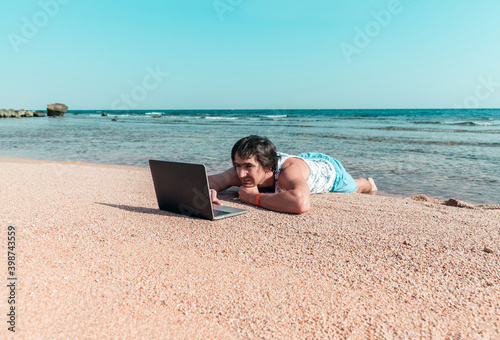 freelancer with a laptop works on a beach © Angelika Smile