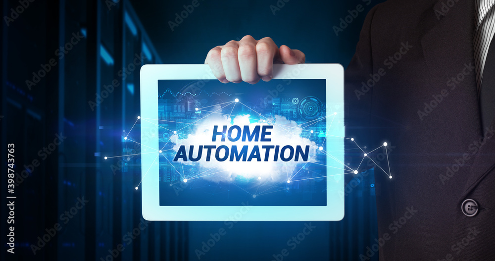 Young business person working on tablet and shows the inscription: HOME AUTOMATION Young business person working on tablet and shows the inscription: HOME AUTOMATION