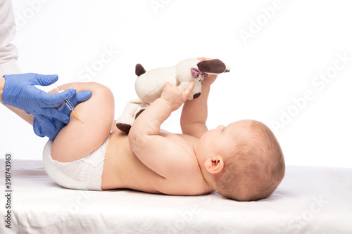 Doctor injecting a vaccine in leg of baby girl photo