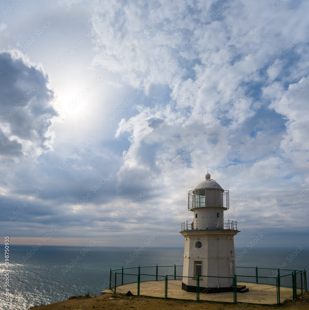 lighthouse stay on marine cape under a dense cloudy sky