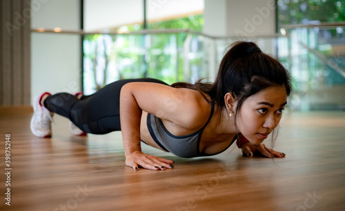 young Asian woman doing push ups in the gym © Near