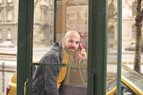 man speaks in a telephone booth © olly