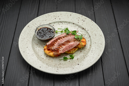 Juicy duck breast steaks with caramelized apple on plate. Hot Meat Dishes