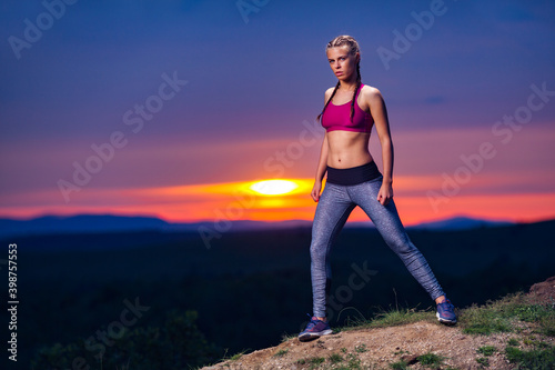 Determined Athletic Fitness Woman in Pose after Running on Hills at Sunset