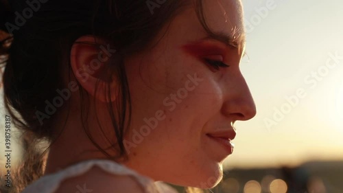 Smiling young beautiful blonde girl with blu eyes looks far away.