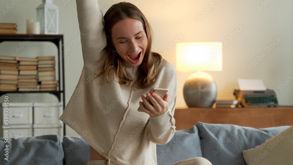 Woman getting good news notification via mobile phone. Girl celebrating victory online using cell phone Woman getting good news notification via mobile phone. Girl celebrating victory online using cell phone
