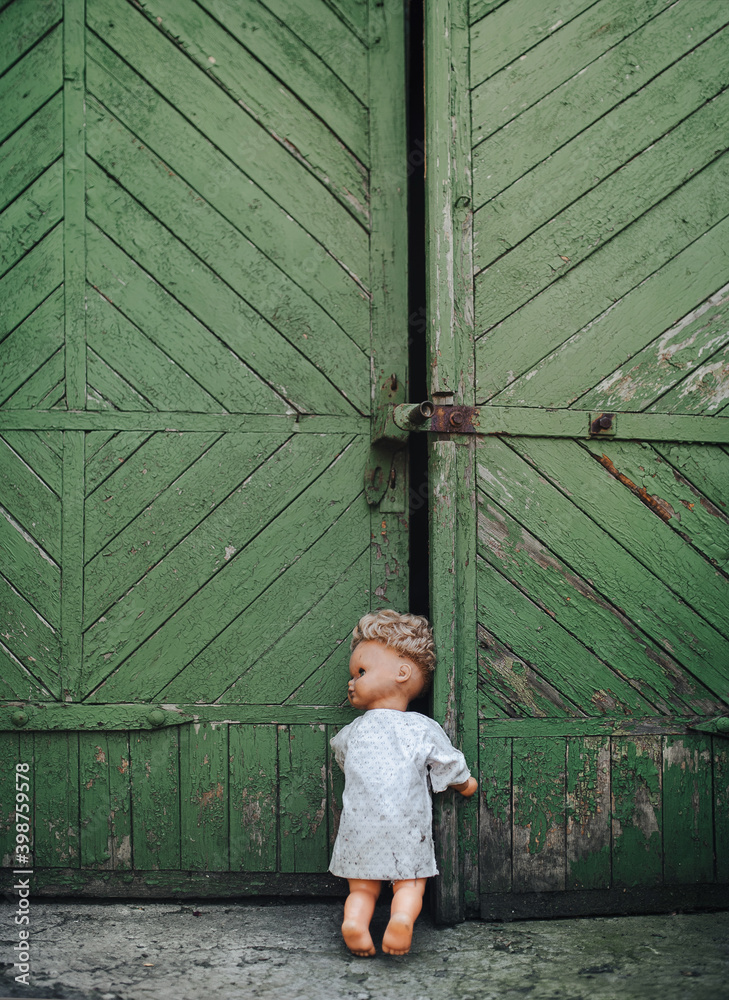 A bad and scary doll turns around and looks out the door, scaring people. Halloween and horror. Waiting for the victim. Bad sleep. A bad and scary doll turns around and looks out the door, scaring people. Halloween and horror. Waiting for the victim. Bad sleep.