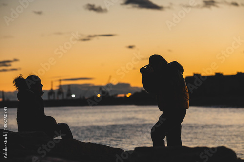 Couple in love take pictures at sunset by the beach