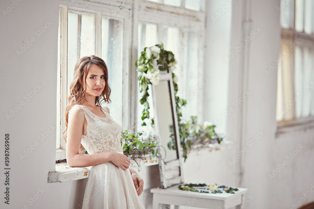 bride portrait in wedding dress near window
