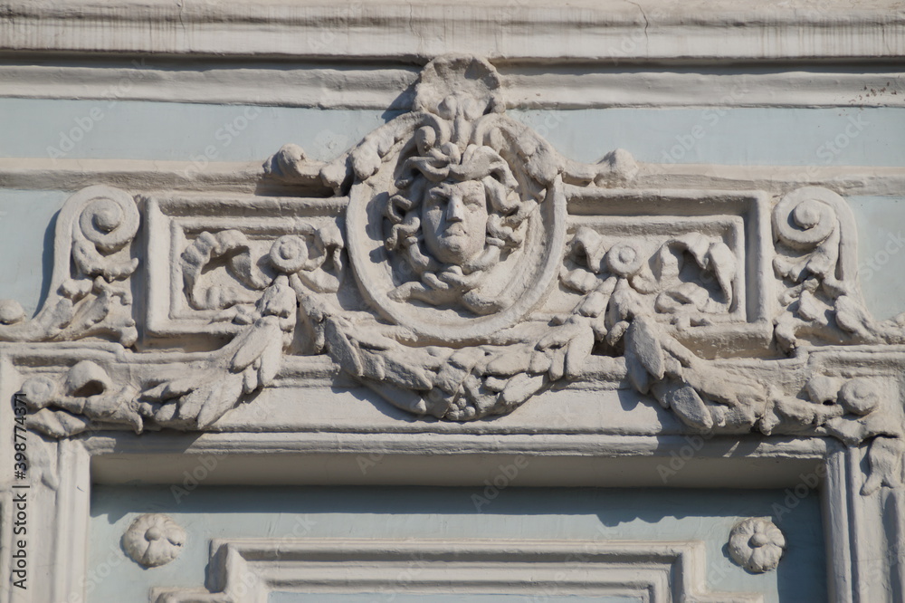 the facade of the building is in a classic style with a decor in the form of an antique head