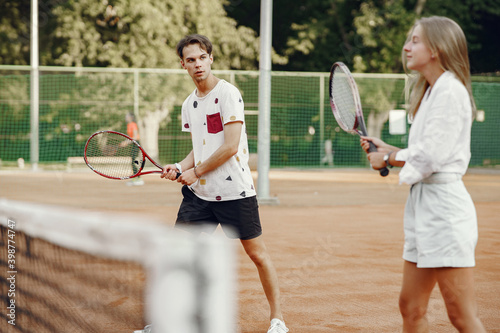 Young couple on tennis court. Two tennis players in a sport clothes.