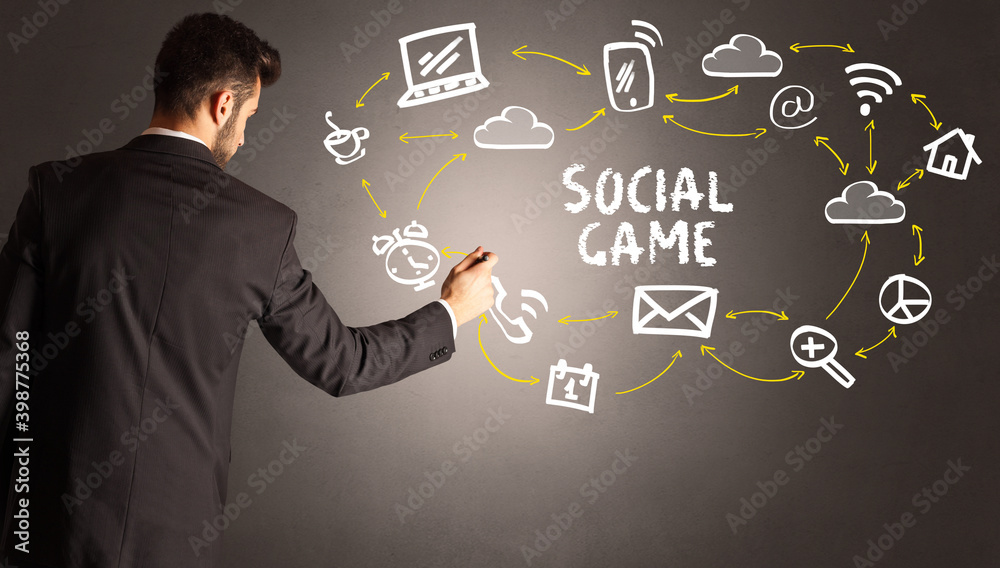 businessman drawing social media icons with SOCIAL GAME inscription, new media concept businessman drawing social media icons with SOCIAL GAME inscription, new media concept