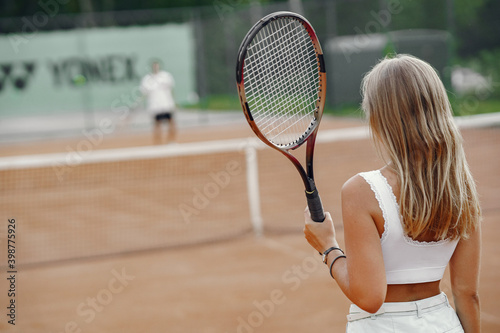 Great day to play Cheerful young woman in t-shirt. Woman holding tennis racket and ball.