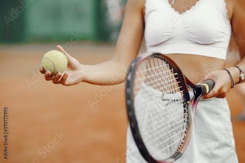 Great day to play Cheerful young woman in t-shirt. Woman holding tennis racket and ball. © hetmanstock2