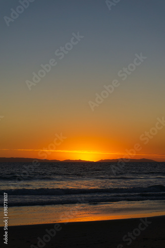 Sunset on the beach. Dramatic sky over the Pacific Ocean from Huntington Beach overlooking the silhouette of Catalina Island.